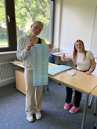 Das Foto zeigt eine Schülerin des TGG mit dem Stimmzettel.