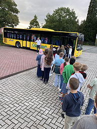 Das Foto zeigt die Schülerinnen und Schüler bei einer Übung zum Einsteigen in einen Schulbus.