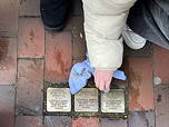 Das Foto zeigt eine Schülerin beim Reinigen und Polieren von Stolpersteinen.