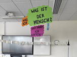 Das Foto zeigt die Vorstellung des Fachs Philosophie beim Grundschul-Infonachmittag (März 2025); Kants vier Fragen hängen von der Klassenraumdecke.