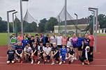 Das Foto zeigt die Schülerinnen und Schüler der 7ems auf dem Sportplatz zusammen mit ihren zwei Lehrerinnen.