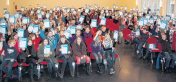 Stolz präsentieren die TGG-Schüler in der Aula ihre Urkunden